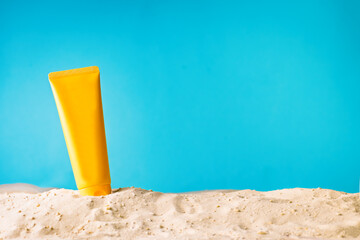 Sunscreen lotion on sandy beach