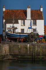 Obraz premium Boat on Harbour Wall at Pittenweem, Fishing Village in the East Neuk of Fife, Scotland