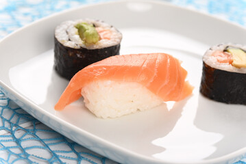 Sushi and rolls on a white plate.