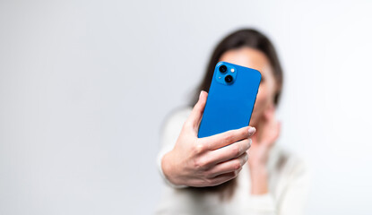Fototapeta premium New technology mobile phone in woman hands. Focus on the hand and phone.