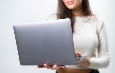 Grey modern laptop in woman hands. Young lady in casual cloth with laptop.