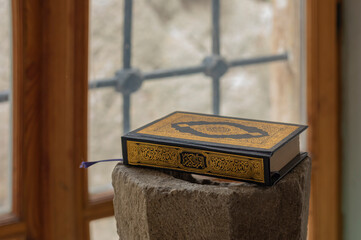 close up of the Quran on a stone plynth