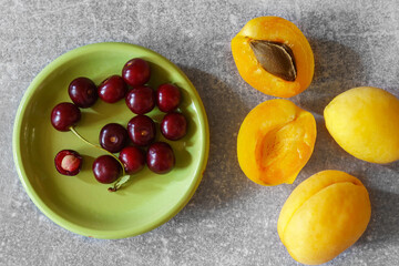 Apricots and cherries on a gray marble table