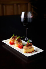 Glass with wine and toasts with delicious paste on table