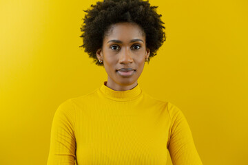 Fototapeta na wymiar Portrait of confident young african american female advisor with afro hairstyle against yellow wall