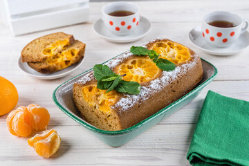 Homemade sweet pie with tangerines, hand made dessert on a wooden table