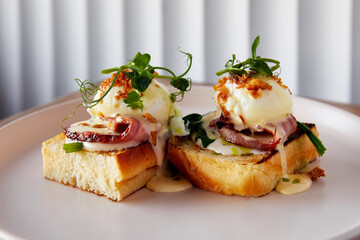 Toasts with Benedict eggs ham and microgreen served on plate