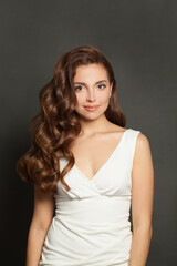 Naklejka premium Brunette woman with long and shiny curly hair and natural makeup. Beautiful model woman with wavy hairstyle