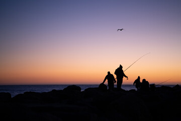 People enjoy the sunset time and fishing at the half moon bay jetty