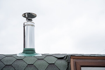 Steel pipe fixed on the roof of the house, chimney in the bath, waterproofing of the roof, metal...
