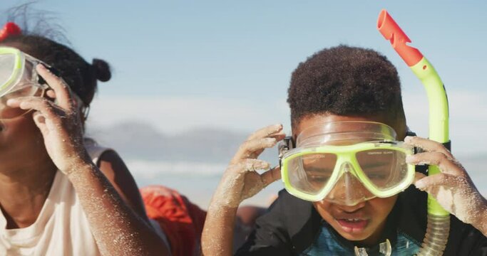 African american brother and sister wearing scuba diving mask with a snorkel at the beach