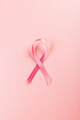 Directly above shot of pink breast cancer awareness ribbon isolated over pink background, copy space