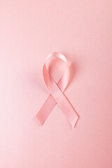 Directly above shot of pink breast cancer awareness ribbon isolated on pink background, copy space