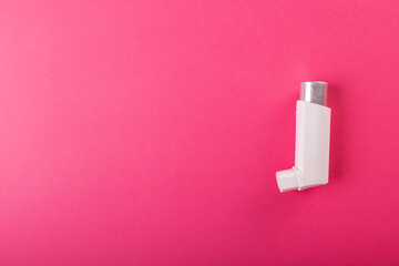 Directly above shot of white asthma inhaler isolated against pink background, copy space - obrazy, fototapety, plakaty
