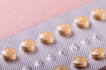 Extreme close-up of blister pack of medicines isolated against pink background, copy space
