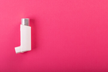 Directly above shot of white asthma inhaler isolated over pink background, copy space