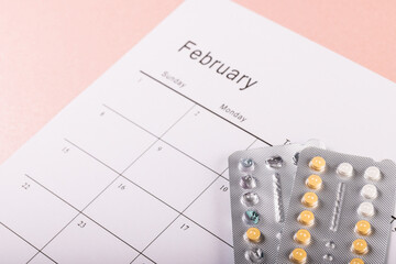 High angle close-up of blister packs of medicines with medication calendar on table, copy space