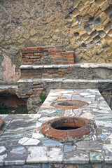 Top view of the ruined remains of the worktop of an ancient Roman tavern, with the exposed openings of the jars, Herculaneum, Campania, Italy