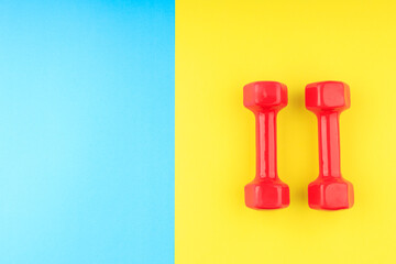 blue-yellow background and red two dumbbells