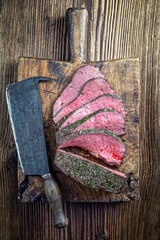 Traditional English Sunday roast with with herbs served as top view on a rustic old wooden board