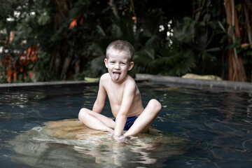 Blond child is resting in the thermal springs pool.