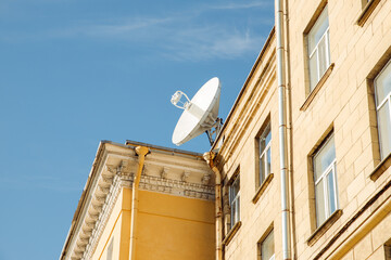 Large satellite dish or satellite antenna on building roof. Sunny day.