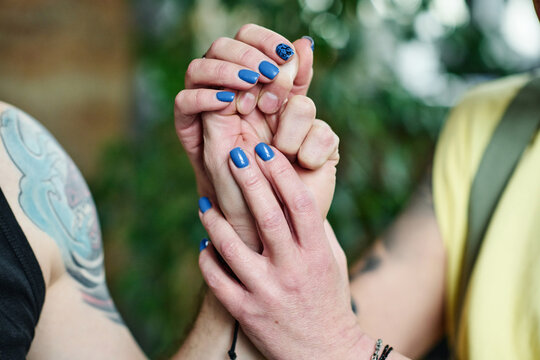 Horizontal close-up shot of unrecognizable woman in love holding hand of her husband, intimacy concept