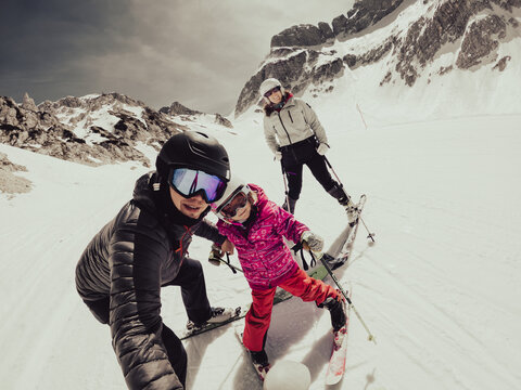 Happy young family taking a selfie at skiing resort.