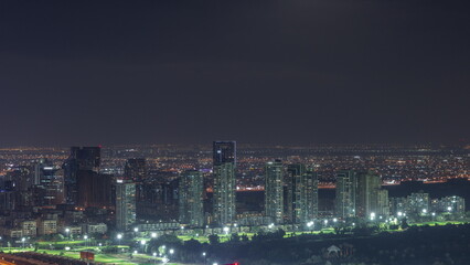 Fototapeta premium Moon rising over greens and al barsha heights district area night timelapse from Dubai marina.
