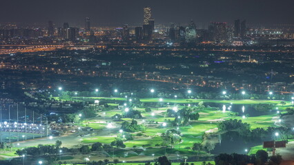 Obraz premium Aerial view to Golf course with green lawn and lakes, villa houses behind it night timelapse.