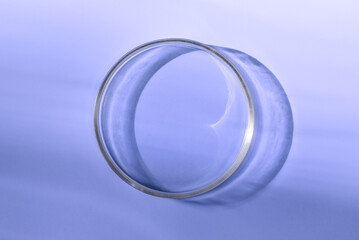 Empty laboratory glass petri for serum, oil, beauty products on violet background. Natural medicine, cosmetic research, bio science. Concept of skincare and analysis. Dermatology. Flat lay, top view