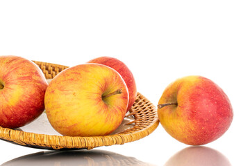 Four juicy organic apples with a ceramic dish, close-up, isolated on a white background.
