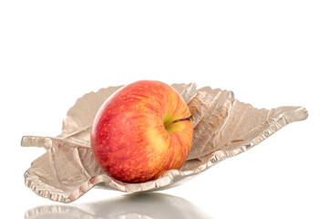 One ripe organic apple with a metal vase, close-up, isolated on a white background.