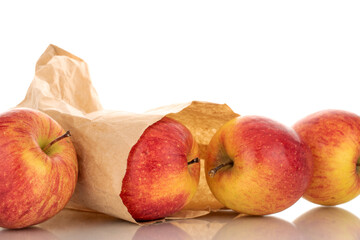 Four juicy organic apples with a paper bag, close-up, isolated on a white background.