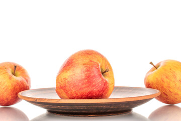 Three juicy organic apples with a clay dish, close-up, isolated on a white background.