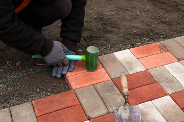 Close-up of a builder installing and laying paving stones on a terrace