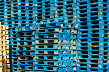 Lot of blue wooden empty pallet stacked at container port waiting for collection