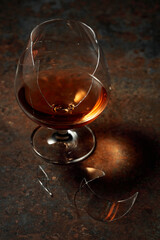 Brandy is in broken glass on a rusty background.