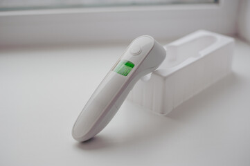 Non-contact thermometer on a white background for measuring body temperature