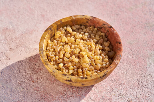 Frankincense resin in a bowl on a table in sunlight