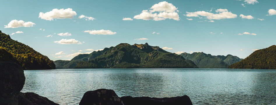 Panoramic view of a calm lake with a beautiful mountain range in the background. Lake Tromen. Neuquen, Argentina