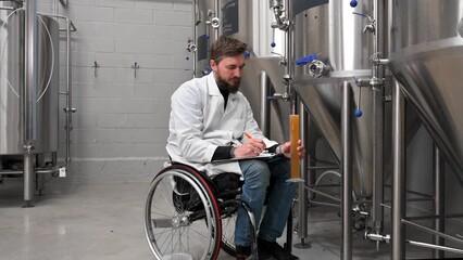Person with disability who uses a wheelchair working at craft beer factory. High quality 4k footage - Powered by Adobe