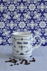 Kaffee in einer blau-weißen Tasse mit Kaffeebohnen