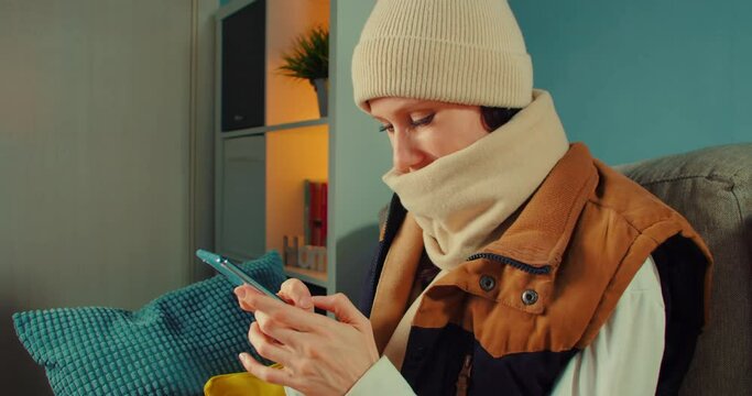 Woman covered in plaid wear hat feels frozen experiences electrical power outage due debt complains chatting on phone with transmission service provider operator. Central heating problems concept