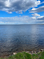 Blue lake water and blue sky with white clouds, bright day, lake view, no people