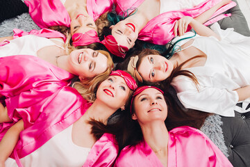Funny girlfriends in pink robes with bride-to-be.