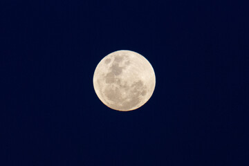 Full moon against a dark blue night sky