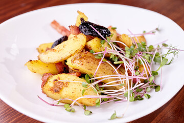 baked potatoes, baked potato dish with microgreens on a white plate close up