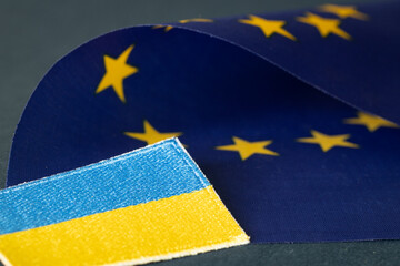 The concept of Ukraine joining the European Union, the Ukrainian flag lying next to the Symbol of...