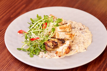 pieces of chicken roll with sauce and microgreens